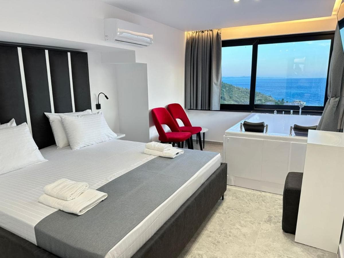 Queen spa room with bed, jacuzzi, and sea window