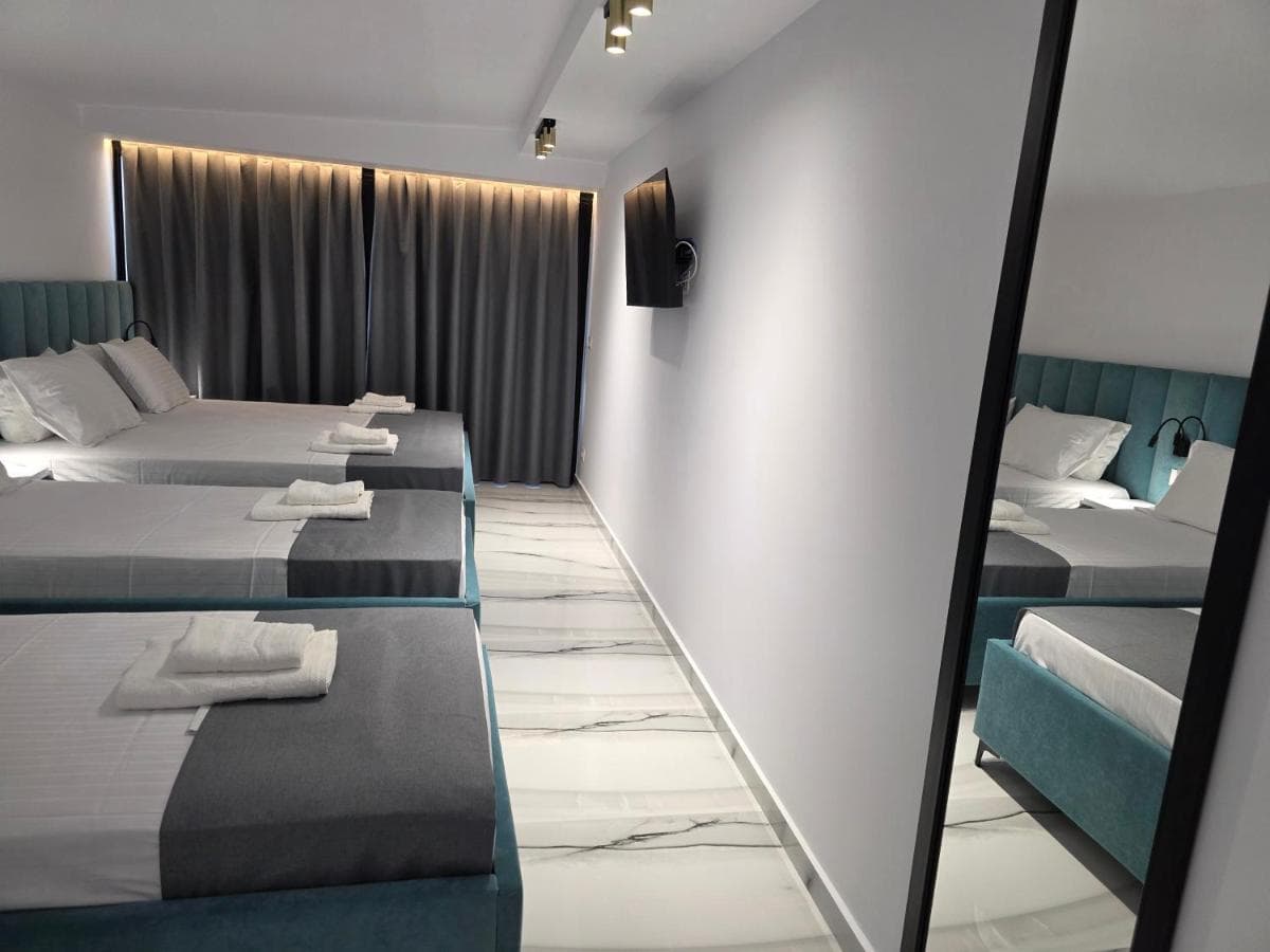 Triple room with three teal-headed single beds